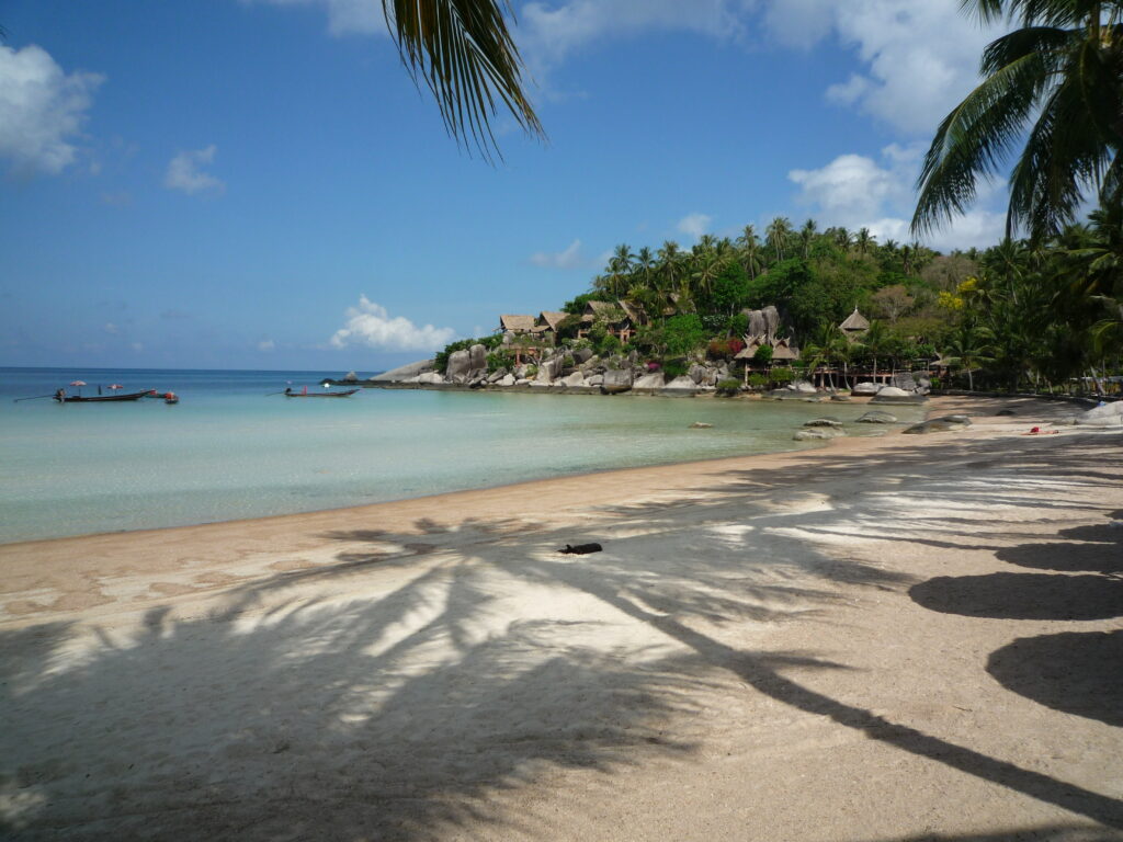 wei Personen in einer professionellen Auswanderungsberatung für Thailand mit Thailand-Flagge am Tisch